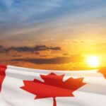 A Canada flag waves under the sunset